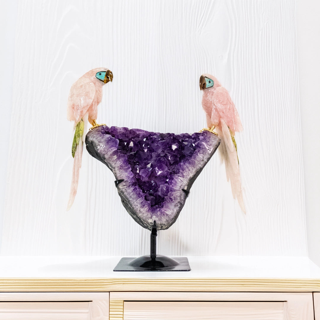 Escultura "Arara Sagrada" em Quartzo Rosa com Detalhes em Serpentinita, Amazonita e Olho de Tigre sobre Drusa de Ametista – 8,7kg